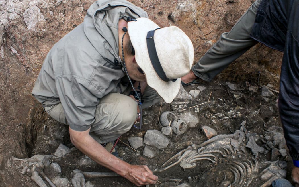 Handout picture released by the Peruvian Ministry of Culture on August 27, 2023 showing an archaeologist next to the remains of a 3,000-year-old priest's tomb, found by a group of Japanese and Peruvian archaeologists under a ceremonial site at the Pacopampa archeological site, in Cajamarca, northeast of Peru. (Photo by Handout / Peruvian Ministry of Culture / AFP) / RESTRICTED TO EDITORIAL USE - MANDATORY CREDIT "AFP PHOTO / PERUVIAN MINISTRY OF CULTURE " - NO MARKETING - NO ADVERTISING CAMPAIGNS - DISTRIBUTED AS A SERVICE TO CLIENTS