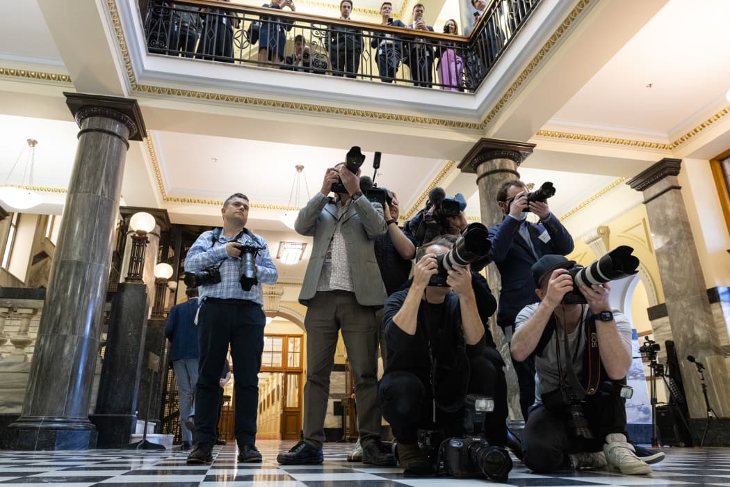Photographers and (above) political and parliamentary staff wait for the Minister of Finance to arrive across 'the bridge' for the budget.