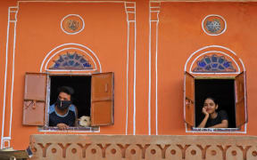 Residents look out from window at walled city during the nationwide Lockdown imposed in the wake of the deadly novel coronavirus pandemic  in Jaipur, Rajasthan,India.