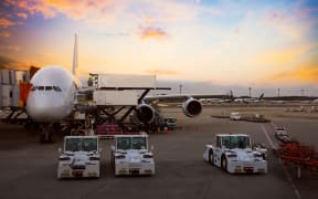 Airplane near the terminal in an airport at the sunset.