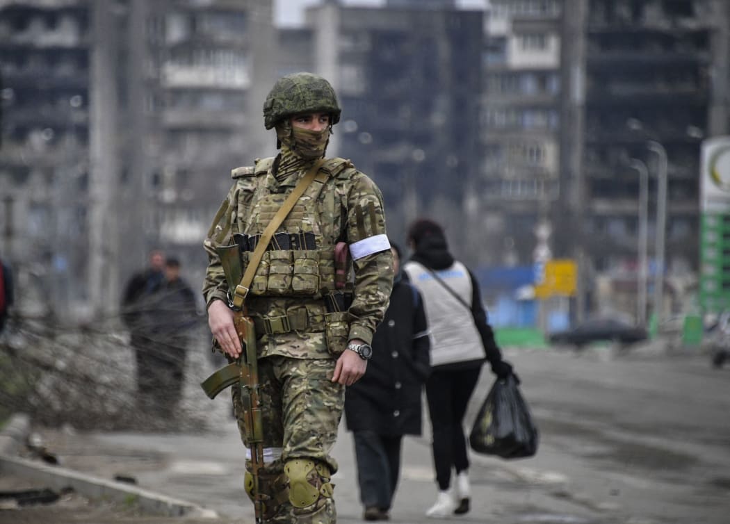 A Russian soldier patrols in a street of Mariupol on April 12, 2022, as Russian troops intensify a campaign to take the strategic port city, part of an anticipated massive onslaught across eastern Ukraine, while Russia's President makes a defiant case for the war on Russia's neighbour.