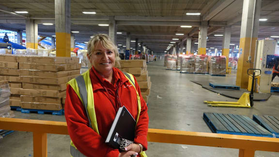 Sue Green from The Warehouse standing in a large distribution centre