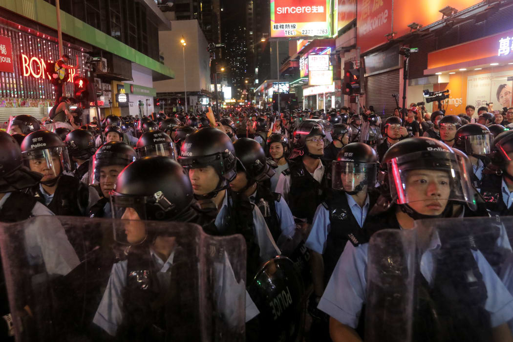 Police gather as they face protesters in the Mong Kok district in Kowloon after taking part in a march to the West Kowloon rail terminus against the proposed extradition bill in Hong Kong on July 7, 2019.