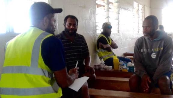 Vanuatu Emergency Medical Team's Dr Jimmy Obed (left) leading a mental health counselling session with Ambaean evacuees.