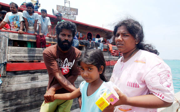 Sri Lankan asylum seekers disembark from their wooden boat in Indonesia.