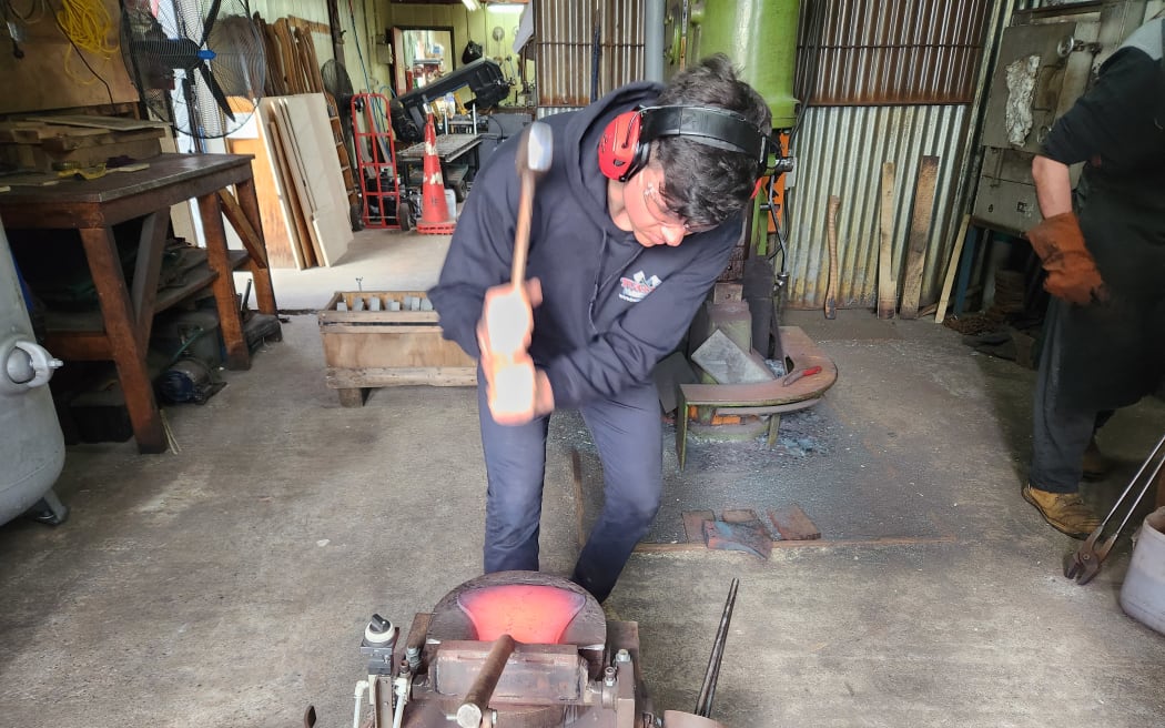 Quintin beats an axe blade during the forging process