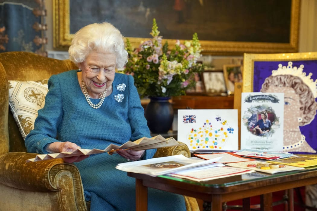 Queen Elizabeth II looking at Queen Victoria's Autograph fan, alongside a display of memorabilia from her Golden and Platinum Jubilees, in the Oak Room at Windsor Castle, west of London in January 2022.
