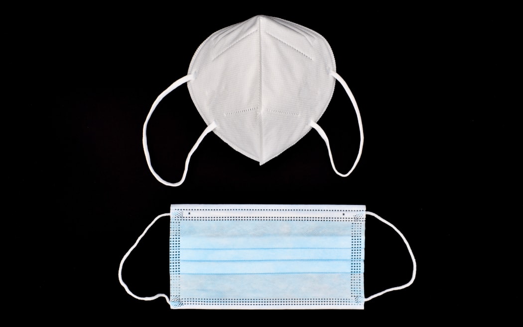 Disposable KN-95 mask vs thin surgical mask. COVID-19 prevention. H1N1, H5N1 safety measures. Isolated on black background.