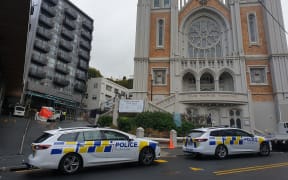 Police examine the small truck, in the alley between apartments and St Mary of the Angels church in central Wellington.