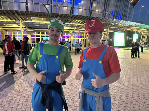 Two young men dressed as the Super Mario Brothers.