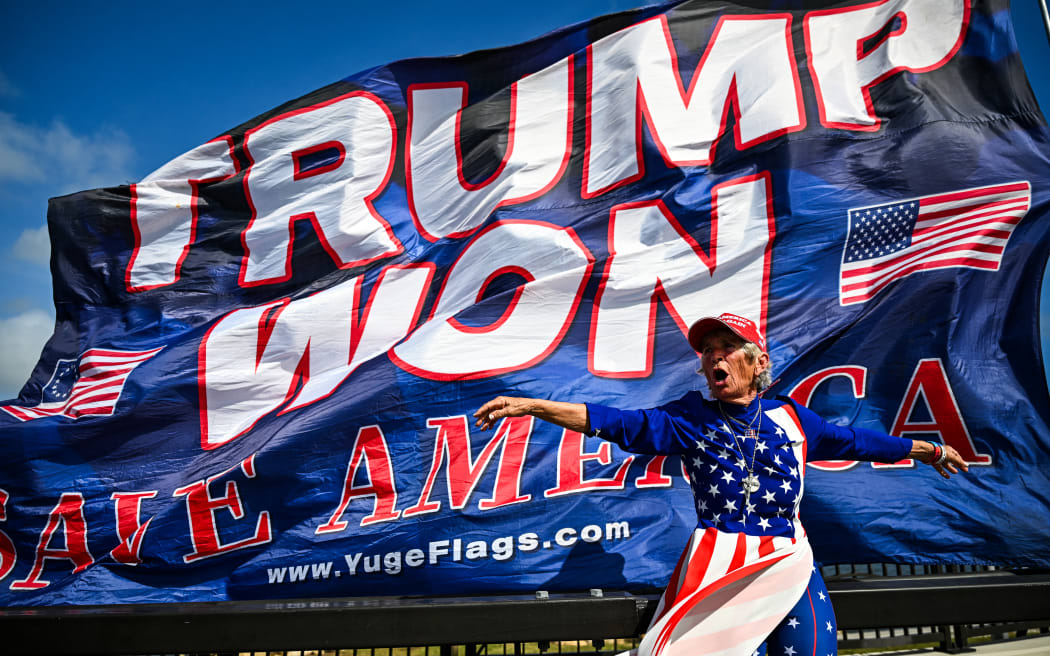 Supporters of former US president and Republican presidential candidate Donald Trump celebrate his victory near his Mar-a-Lago resort in Palm Beach, Florida, on November 6, 2024. - Donald Trump won a sweeping victory Wednesday in the US presidential election, defeating Kamala Harris to complete an astonishing political comeback that sent shock waves around the world. (Photo by CHANDAN KHANNA / AFP)