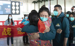 A medical worker from the Peking Union Medical College Hospital bids farewell to a local medical worker at the Wuhan Tianhe International Airport in Wuhan, capital of central China's Hubei Province, April 15, 2020.