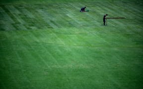 Staff members work on the pitch at the Olympic Stadium in Tokyo, the morning after the closing ceremony for the 2020 Tokyo Olympic Games.