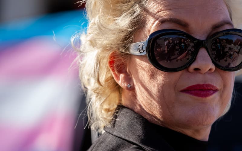Anti-transgender activist Posie Parker with a trans flag in the background.