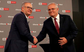 Australian Prime Minister Scott Morrison (R) shakes hands with leader of the opposition, Anthony Albanese, during the first leaders' debate of the 2022 federal election campaign at the Gabba in Brisbane on April 20, 2022.