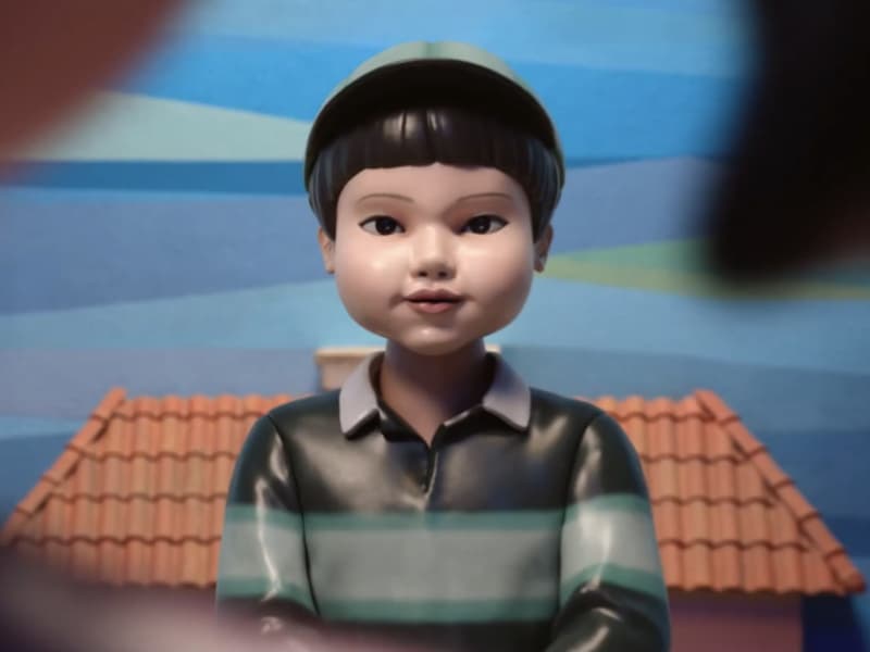 A robot with a bowl slightly smiles at the camera.