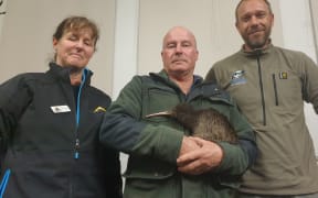 Taranaki Kiwi Trust's Sue Hardwick-Smith, truck driver Alan Pennington and Simon Collins, sanctuary manager at Rotokare Scenic Reserve with Papa the kiwi.