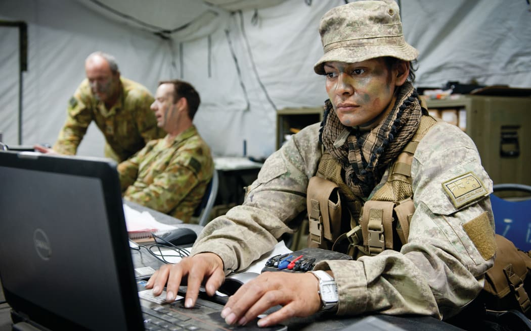 Member of the New Zealand Defence Force on a laptop in uniform
