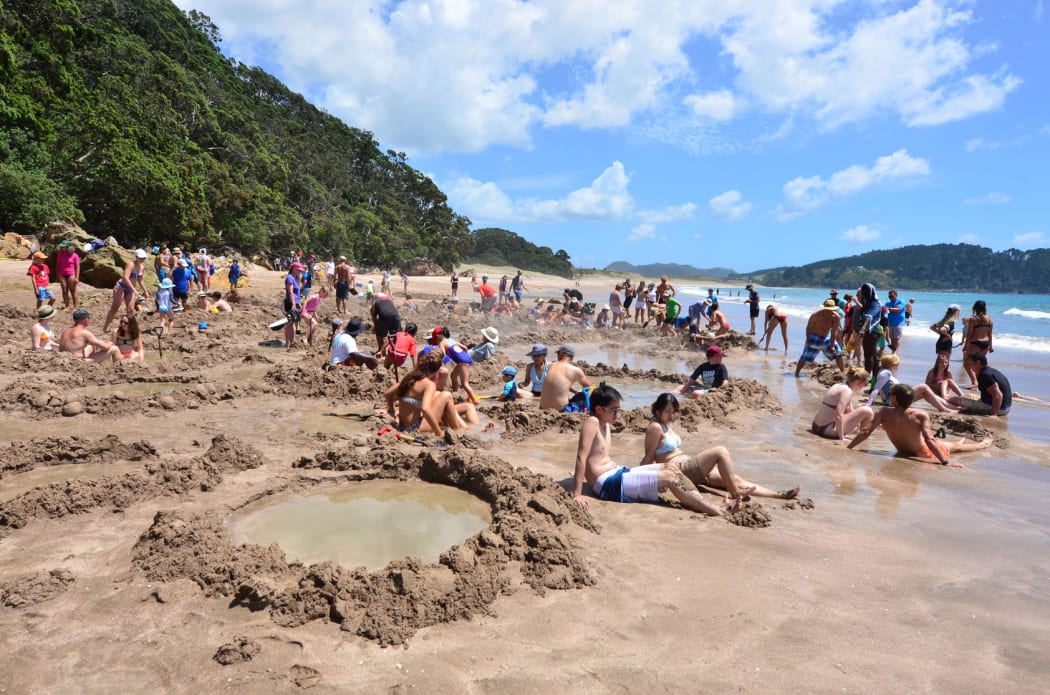 Visitors making small hot water pools in Hot Water beach