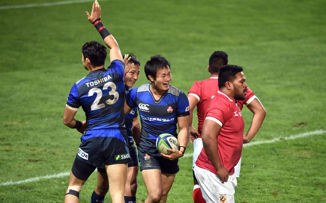 Japan celebrate one of their five tries against Tonga in Toulouse.