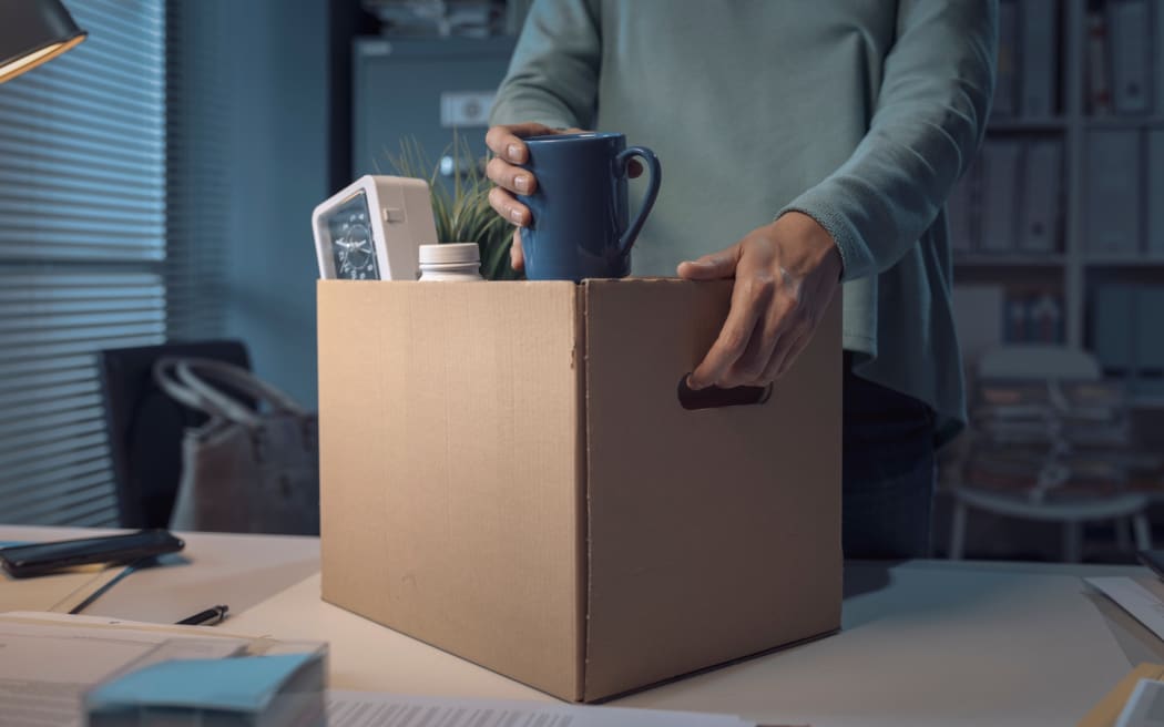 P)erson packing her belongings in the office after being fired.