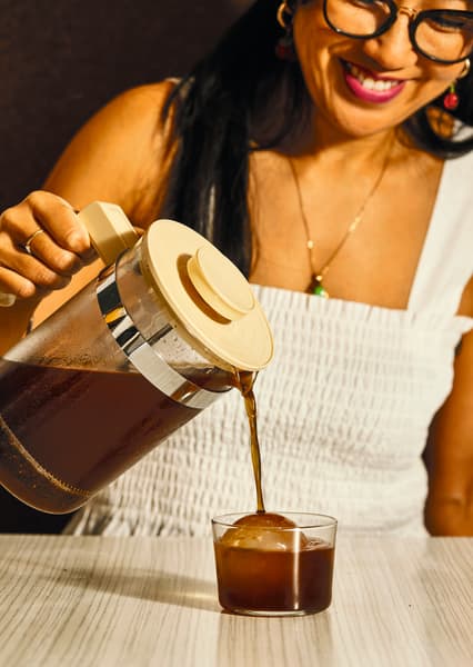 An image from Celeste Wong's book, Coffee Creations: 90 delicious recipes for the perfect cup. Celeste Wong pours coffee on ice for a cold brew.