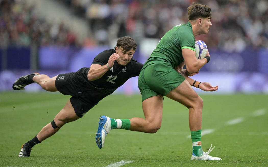 Ireland's Zac Ward (R) is chased by New Zealand's Leroy Carter (L) during the men's placing 5-6 rugby sevens match between New Zealand and Ireland during the Paris 2024 Olympic Games at the Stade de France in Saint-Denis on July 27, 2024.