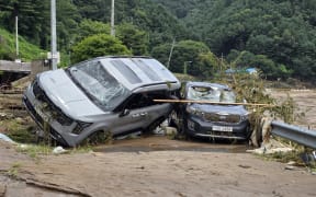 Cars damaged by floodwater are seen on a road along the river due to heavy rain in Gapyeong county on July 20, 2025. At least two people were killed during heavy downpours early on July 20, the interior ministry said, bringing the death toll to 14 as South Korea has been hit by torrential rainfall this week. (Photo by YONHAP / AFP) / - South Korea OUT / NO USE AFTER AUGUST 19, 2025 15:00:00 GMT -  - SOUTH KOREA OUT / NO USE AFTER AUGUST 19, 2025 15:00:00 GMT -  - SOUTH KOREA OUT / NO ARCHIVES -  RESTRICTED TO SUBSCRIPTION USE