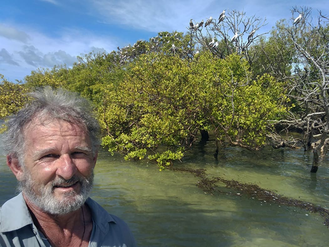 Kennedy with roosting red-footed boobies on Cosmoledo Atoll, in the Indian Ocean.