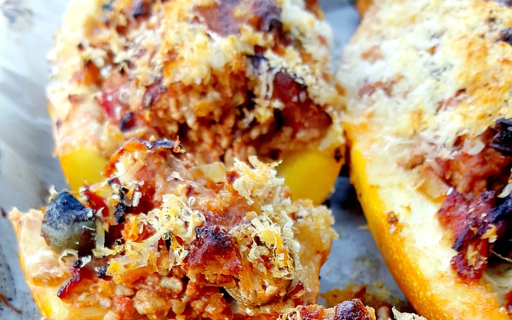 Slices of yellow marrow stuffed with a mix of breadcrumbs, chorizo sausage and olives on a baking paper-lined tray.