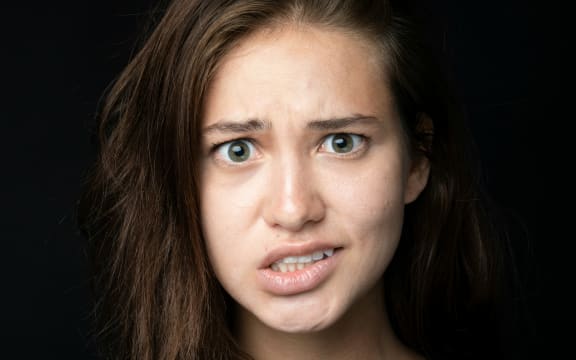 A woman makes an awkward facial expression.