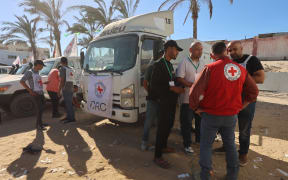 Red Crescent vehicles and refrigerated trucks are parked at the Nasser hospital in Khan Yunis in the southern Gaza Strip on 15 October, 2025, after transporting the bodies of Palestinians that had been in Israeli custody. Under the ceasefire deal brokered by the US president, Israel was to turn over the bodies of 15 Palestinians for every deceased Israeli returned.