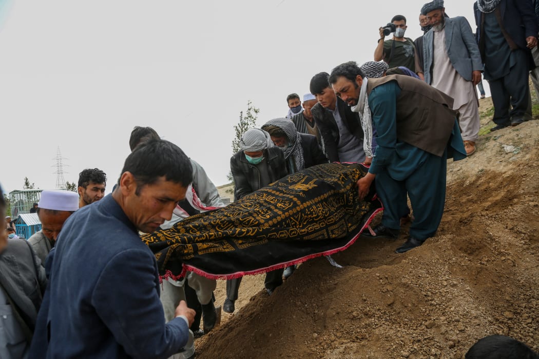 Mourners burying a loved one, following a suicide attack in a maternity hospital in Kabul.