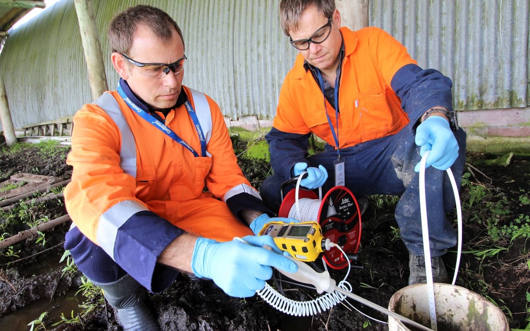 Northland Regional Council staff taking bore water for testing after the pipeline break at Ruakaka.