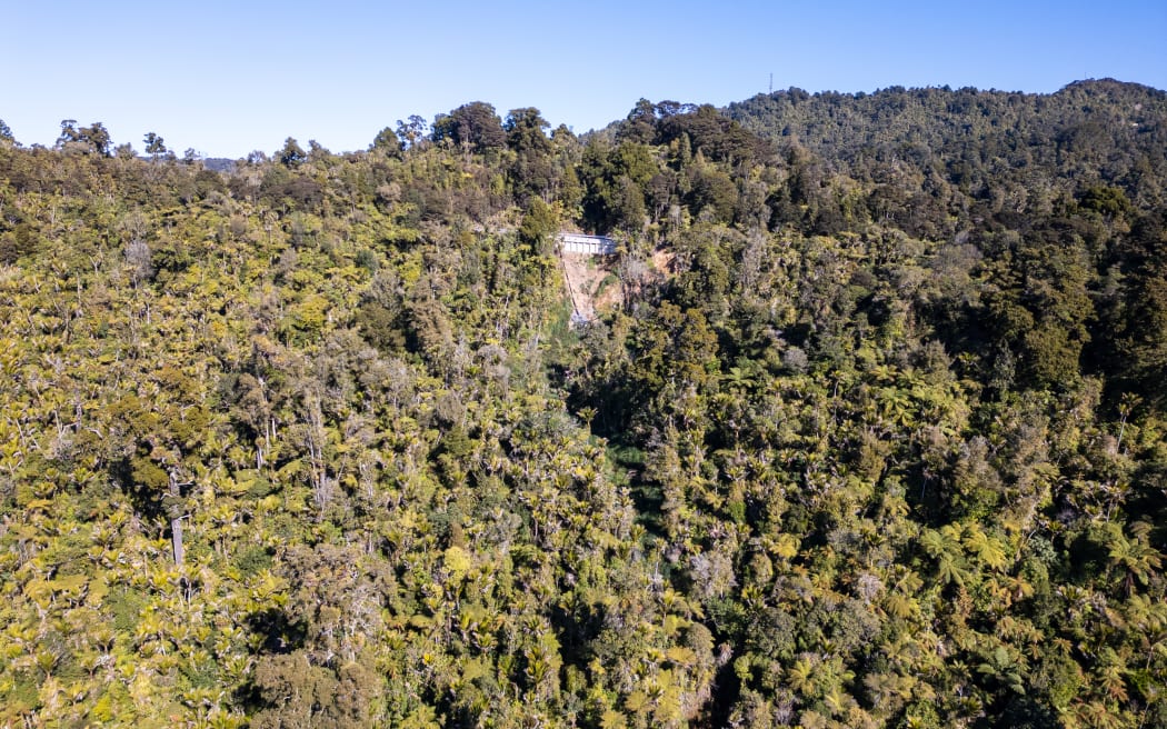 The road slip at "Scenic 6," seen at centre from afar, gouged out a new view from the Waitākere Ranges.