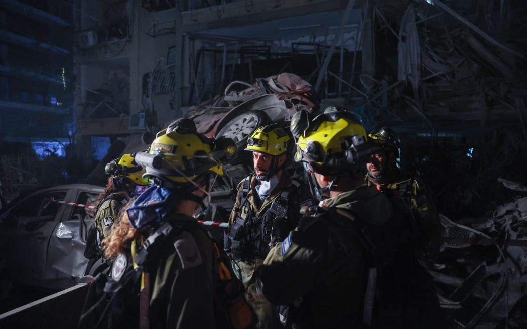 Members of the Israeli security forces inspect a site hit by a missile fired from Iran, in Ramat Gan on the outskirts of Tel Aviv on June 13, 2025. Iran fired a barrage of ballistic missiles at Israel in a counter-strike on June 13, after an unprecedented onslaught hammered the Islamic republic's top military brass and targeted its nuclear facilities and bases. (Photo by Jack GUEZ / AFP)