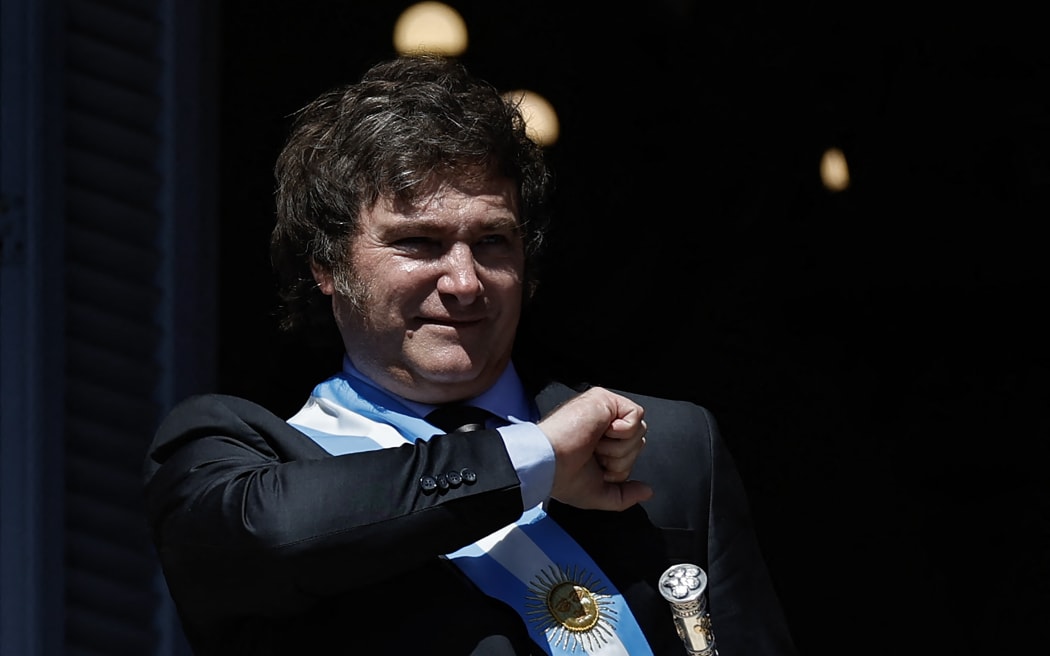 Argentina's new president Javier Milei gestures at the crowd from a balcony of Casa Rosada Presidential Palace on his inauguration day in Buenos Aires.