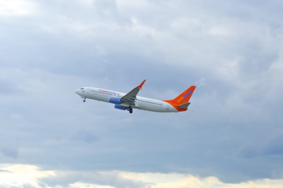 A Sunwing passenger jet can be seen above Trudeau Airport in Montreal, Canada on 3 July, 2016.