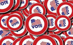 Badges with the American flag a "vote" written on them