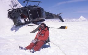 A photo of Don Bogie with the crashed Iroquois helicopter at the Upper Empress Shelf on Mt Cook