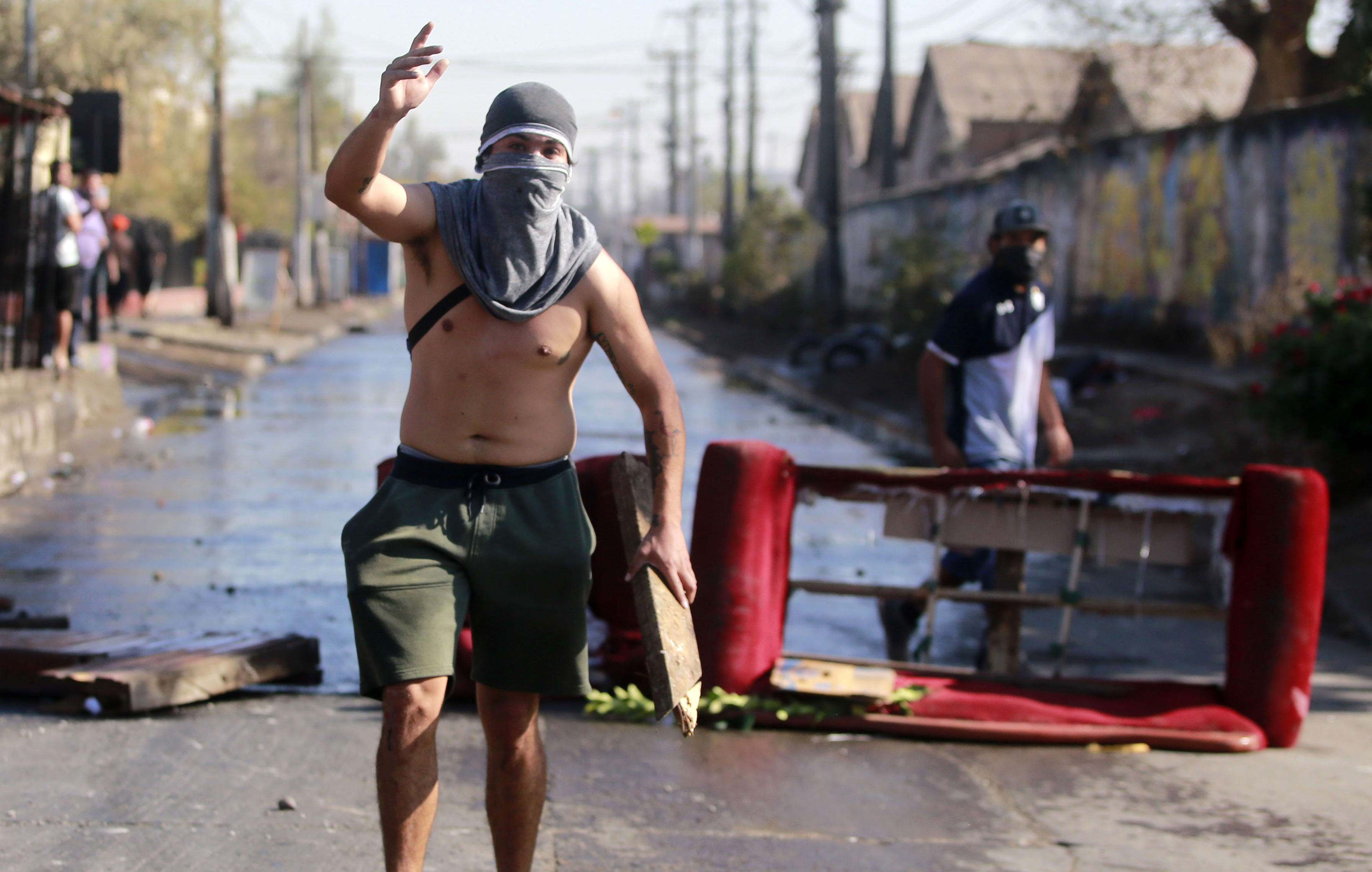 A demonstrator gestures during clashes with riot police within a protest against Chilean President Sebastian Pinera's government amid the Covid-19 pandemic.