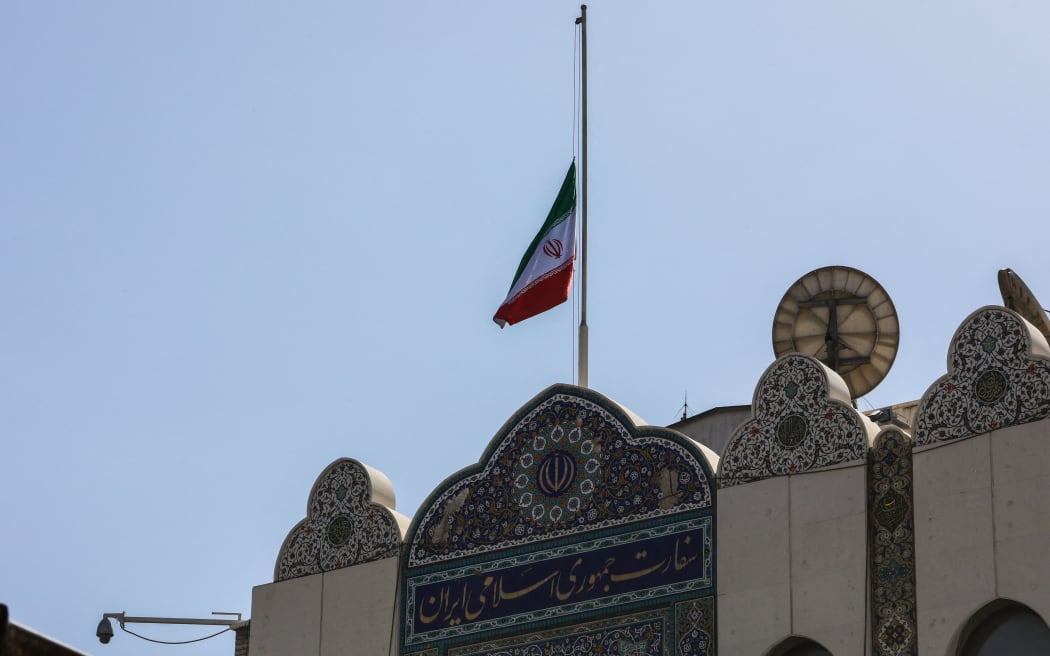 The Iranian national flag flies at half-mast at the embassy building a day after an air strike hit a building annexed to the embassy in Damascus on April 2, 2024. Iran warned arch foe Israel on April 2 that it will punish an air strike that killed seven Revolutionary Guards, two of them generals, at its consular annex in Damascus. (Photo by Louai Beshara / AFP)