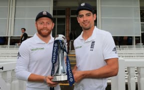 England's captain Alastair Cook (R) and man of the series Jonny Bairstow pose with the trophy at the end of the final day of the third Test match against Sri Lanka at Lord's in London, on June 13, 2016. The game ended in a draw, England winning the series 2-0 Graham Morris / POOL / AFP