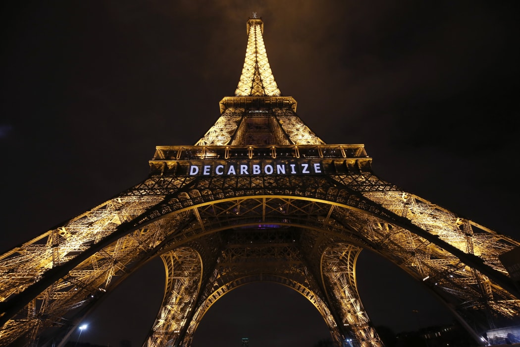 The Eiffel Tower displays the message "decarbonize" within the United Nations Climate Conference on Climate Change, on 11 December 2015 in Paris.