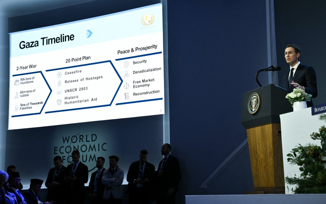 US businessman Jared Kushner speaks as a "Gaza Timeline" is displayed on a giant screen at the "Board of Peace" meeting during the World Economic Forum (WEF) annual meeting in Davos on January 22, 2026. US President Donald Trump will show off his new "Board of Peace" at Davos on January 22, 2026 burnishing his claim to be a peacemaker a day after backing off his own threats against Greenland. Originally meant to oversee the rebuilding of Gaza after the war between Hamas and Israel, the board's charter does not limit its role to the Strip, and has sparked concerns that Trump wants it to rival the United Nations.