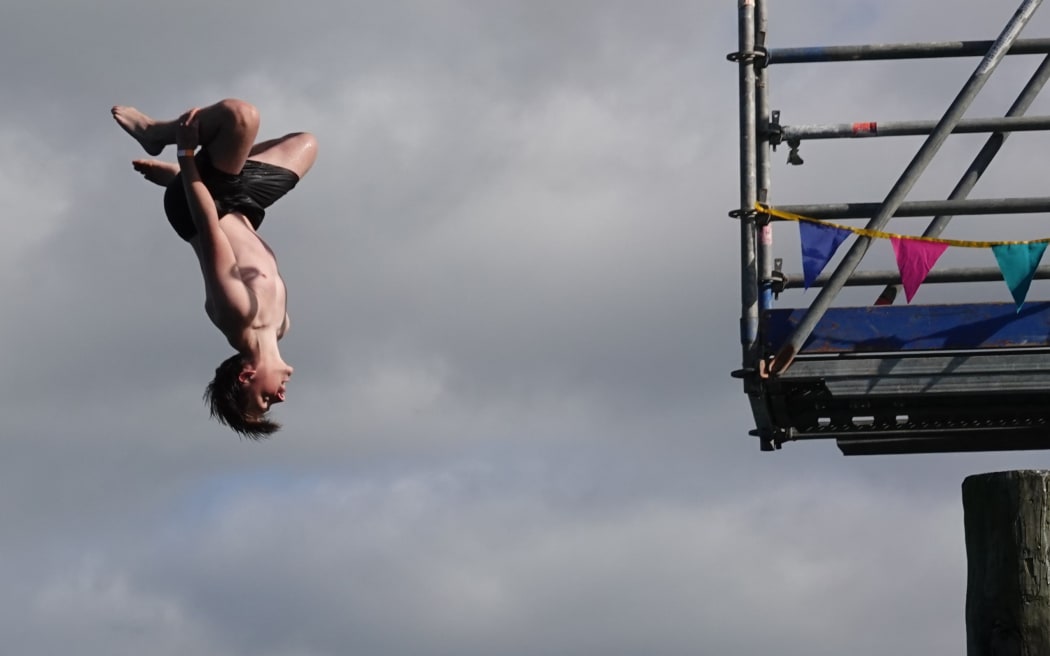 Auckland’s Theo Guthrie, 16, launches himself upside-down into the Bay of Islands.