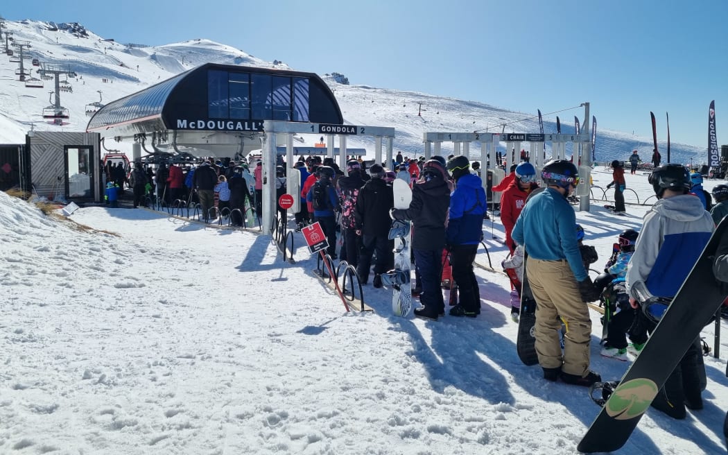 Skiiers and snowboarders line up at Cardrona Alpine Resort.