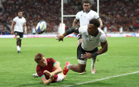 Fiji's full back Sireli Maqala (right) passes the ball ahead of Portugal's fly-half Jeronimo Portela (left) during the France 2023 Rugby World Cup Pool C match between Fiji and Portugal at the Stade de Toulouse in Toulouse, southwestern France on October 8, 2023.