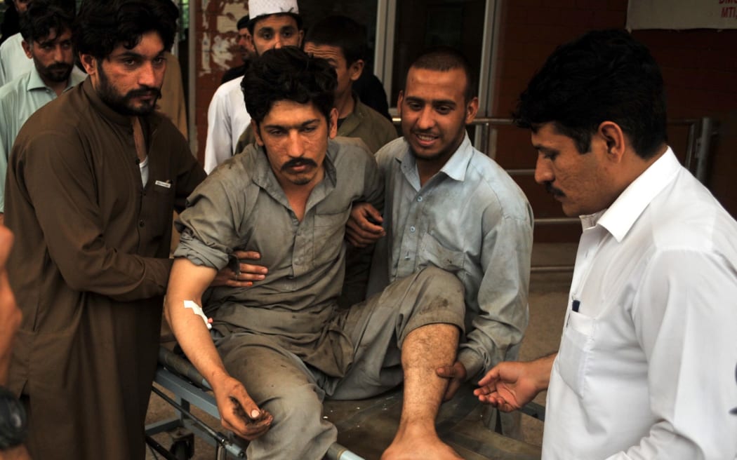 People carry an injured victim to a hospital in the northwestern city of Peshawar, Pakistan.