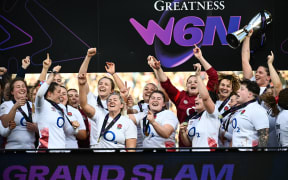 England's players lift the Six Nations trophy after winning the Women's Six Nations Grand Slam at the end of the Six Nations international women's rugby union match between France and England at Chaban-Delmas Stadium in Bordeaux, on April 27, 2024. (Photo by Christophe ARCHAMBAULT / AFP)